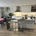 Modern open-plan kitchen with island and bar stools in a host family home in Lyon.