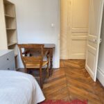 Private student bedroom in central Lyon with desk, storage and traditional wooden flooring.