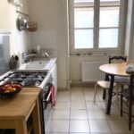 Bright family kitchen with dining table in a homestay apartment in central Lyon.