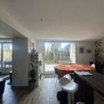 Family dining area with large glass doors opening onto a private garden in a Lyon homestay.