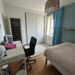 Private student bedroom with desk, office chair, built-in wardrobe and double bed in Lyon.
