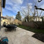 Private garden with terrace, outdoor dining table and trees at a host family home in Lyon.