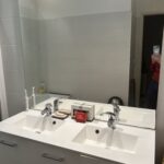 Modern shared bathroom with double washbasin and large mirror in a Lyon host family home.