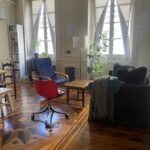 Bright family living room with large windows, seating area and wooden parquet flooring in Lyon.