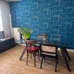 Bright dining area with glass table and blue feature wall in a Lyon host family home