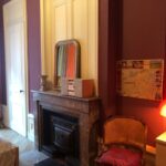 Student bedroom with fireplace, armchair and colourful decor in a traditional apartment in central Lyon.