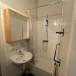 Private shower room with shower, washbasin and mirrored cabinet in a host family apartment in Lyon.