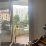 Student bedroom with direct access to a private balcony in a Lyon host family apartment.