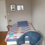 Comfortable student bedroom with single bed and seating area in a Lyon homestay.