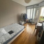 Spacious international student bedroom with bed, desk and balcony in Lyon.