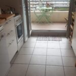 Fully equipped kitchen with direct access to a balcony in a Lyon host family apartment.