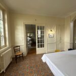 Spacious dining room with traditional tiled floor and large windows in a host family home near Lyon.
