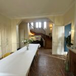 Large family dining room with patterned floor, dining table and wooden staircase in Tassin-la-Demi-Lune near Lyon.