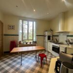 Bright and spacious family kitchen with large window and dining table in a homestay near Lyon.