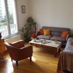 Bright and comfortable living room with sofas and wooden floors in a Lyon host family apartment.